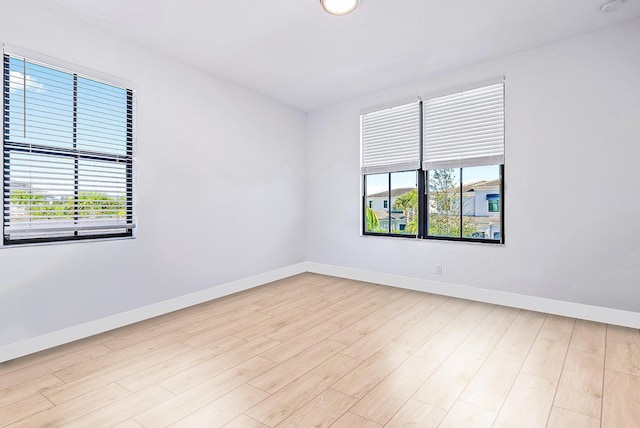 unfurnished room featuring a healthy amount of sunlight and light wood-type flooring