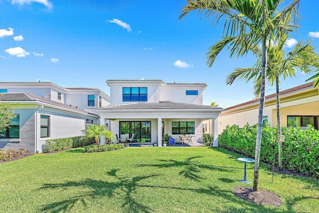 back of property featuring a lawn and a patio area