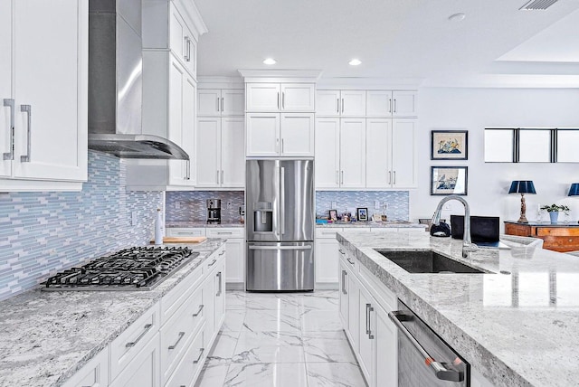 kitchen with white cabinetry, wall chimney range hood, sink, and appliances with stainless steel finishes