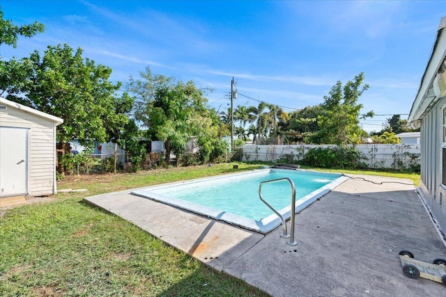 view of pool with a patio area and a lawn