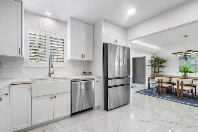 kitchen with white cabinets, decorative backsplash, sink, and stainless steel appliances