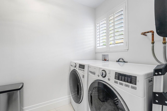 laundry room featuring light tile patterned floors and washing machine and clothes dryer