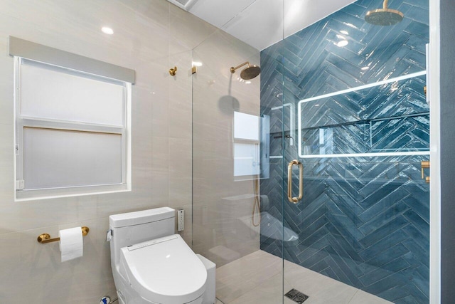 bathroom featuring a shower with shower door, tile walls, and toilet