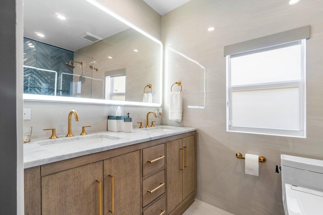 bathroom with vanity, toilet, tile walls, and plenty of natural light