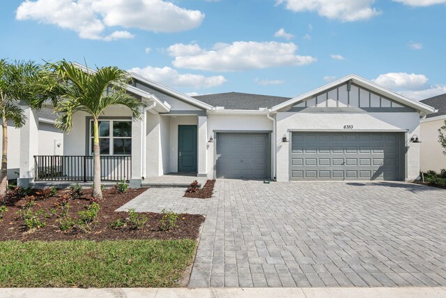 view of front of house featuring a front yard, a garage, and covered porch