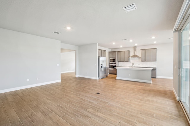 unfurnished living room featuring light hardwood / wood-style floors and sink