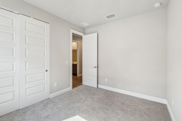 unfurnished bedroom featuring carpet and a closet