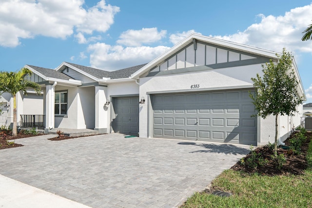 view of front of property with a garage and central air condition unit