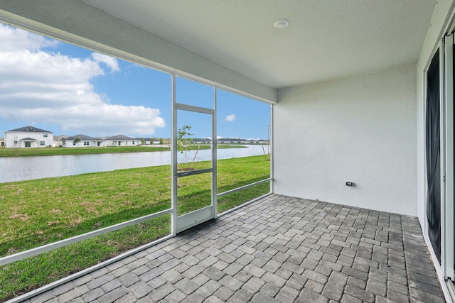 unfurnished sunroom featuring a water view