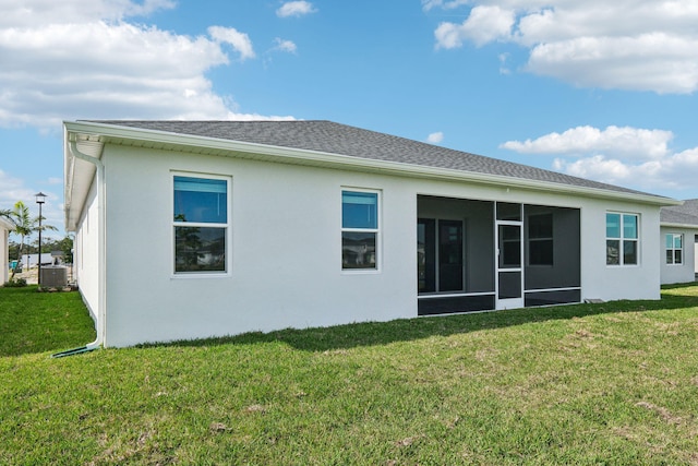 back of property with central AC, a lawn, and a sunroom