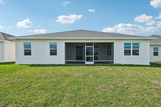 rear view of property featuring a yard and a sunroom