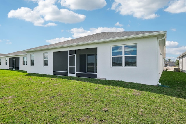 rear view of property featuring a sunroom and a yard