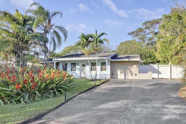 single story home featuring a front yard and a garage