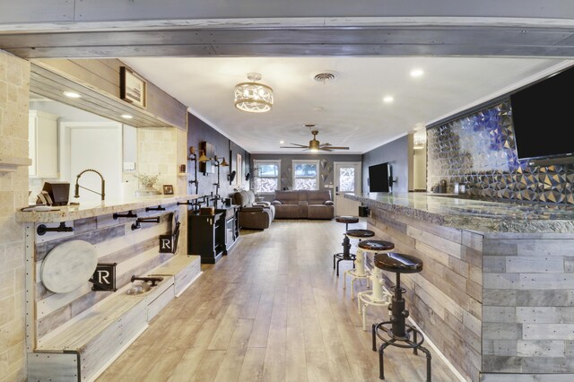 bar featuring hardwood / wood-style floors, crown molding, and ceiling fan