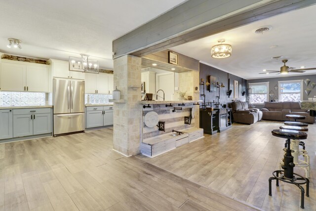 interior space featuring light stone counters, white cabinetry, ceiling fan, and light wood-type flooring