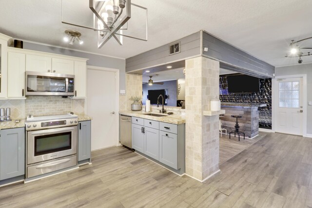 kitchen with pendant lighting, white cabinets, stainless steel refrigerator, and kitchen peninsula