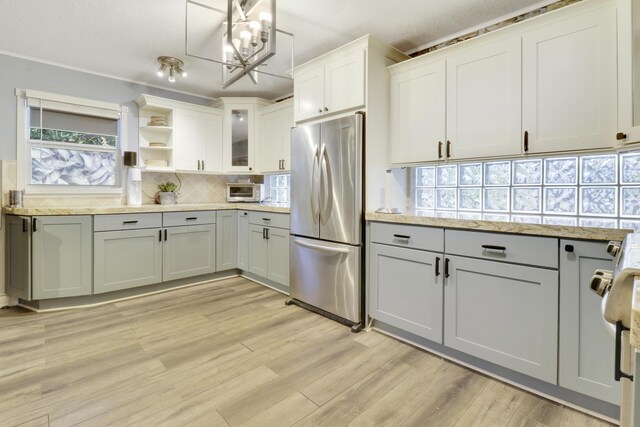 kitchen with tasteful backsplash, dishwasher, light stone countertops, and sink