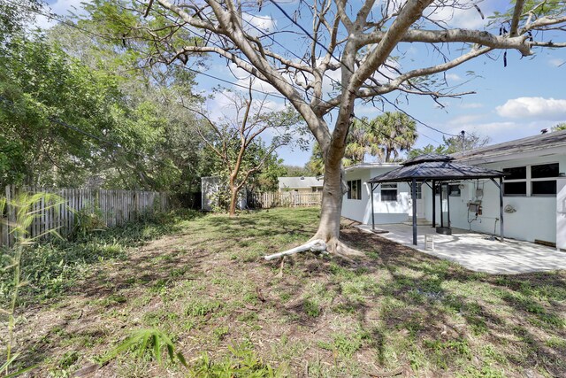 back of property featuring a gazebo, a yard, and a patio area