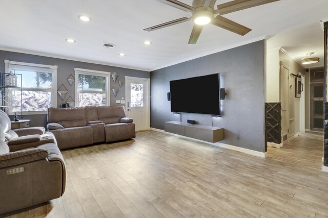 living room with crown molding, ceiling fan, and light wood-type flooring