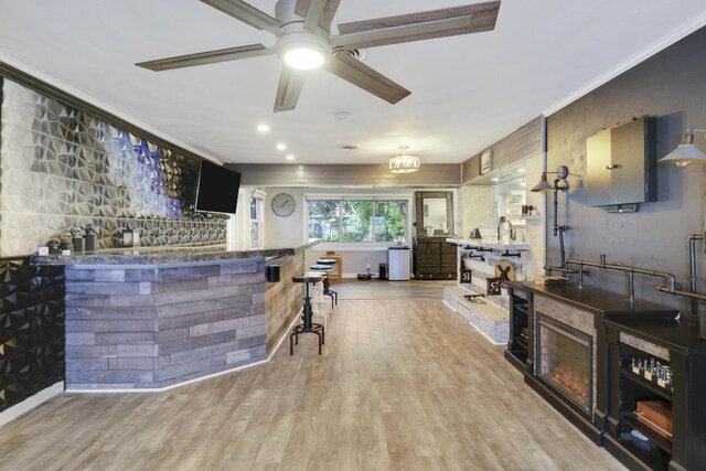 living room with crown molding, ceiling fan, and light hardwood / wood-style flooring