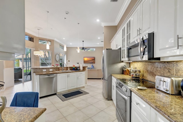 kitchen with stainless steel appliances, white cabinets, hanging light fixtures, and sink