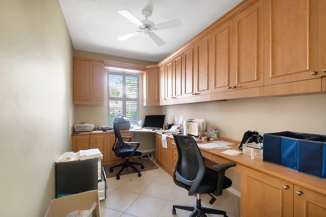 tiled office space with built in desk, ceiling fan, and a textured ceiling