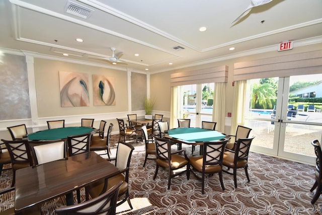 dining room with ceiling fan, crown molding, french doors, and dark colored carpet