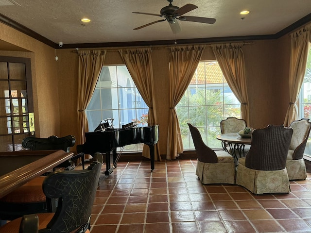 dining room featuring a textured ceiling, ceiling fan, and ornamental molding