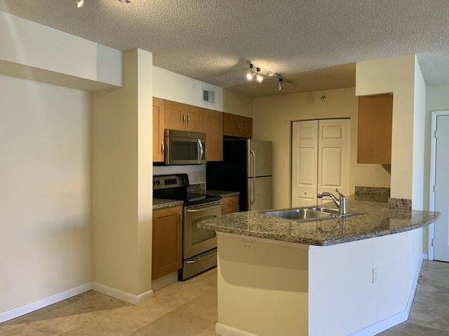 3113 Clint Moore Rd Unit 103, Boca Raton, FL 33496 - kitchen with appliances with stainless steel finishes, a sink, rail lighting, a peninsula, and a textured ceiling