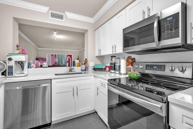 kitchen with white cabinets, sink, ornamental molding, and stainless steel appliances