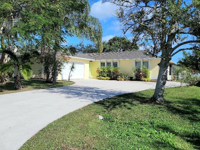 ranch-style home featuring a front lawn and a garage