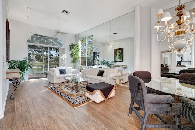 living room featuring ceiling fan with notable chandelier