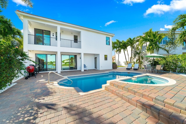 view of pool with an in ground hot tub and a patio