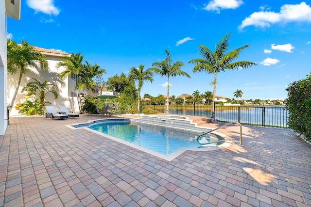 view of pool featuring an in ground hot tub, a patio, and a water view