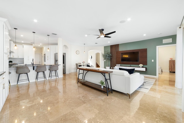 living room featuring ceiling fan and sink