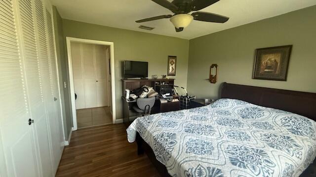 bedroom with dark hardwood / wood-style floors and ceiling fan