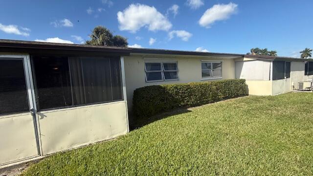 view of side of home with a yard and central AC unit