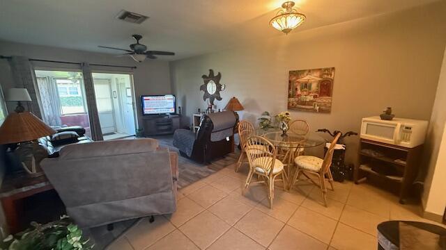 tiled living room with ceiling fan