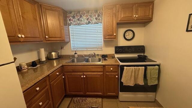 kitchen featuring white appliances, sink, and light tile patterned floors