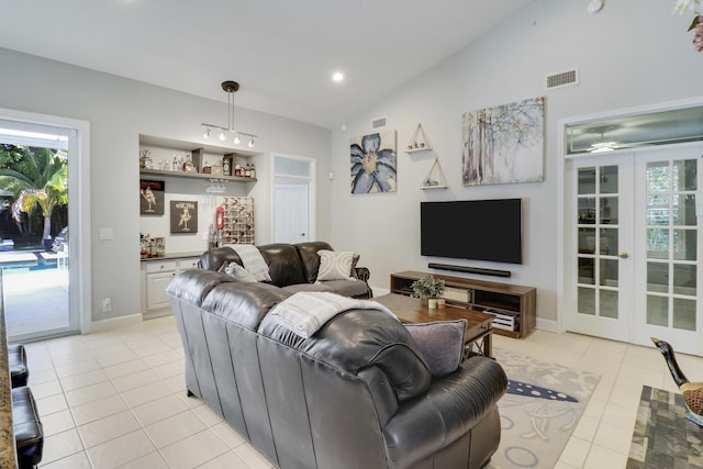 living room with ceiling fan, light tile patterned floors, french doors, and vaulted ceiling