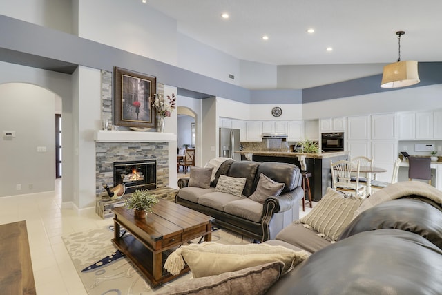 living room with a fireplace, a high ceiling, and light tile patterned floors