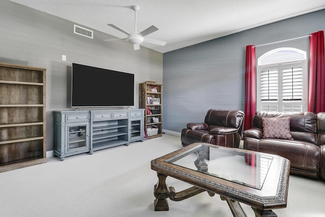 living room featuring carpet flooring, ceiling fan, and a textured ceiling