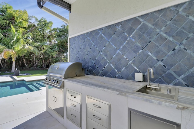 view of patio featuring area for grilling and sink