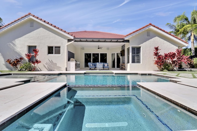 view of swimming pool with an in ground hot tub, an outdoor living space, ceiling fan, exterior kitchen, and a patio area