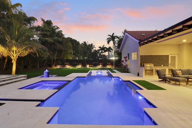 pool at dusk featuring an in ground hot tub, a patio, area for grilling, and grilling area