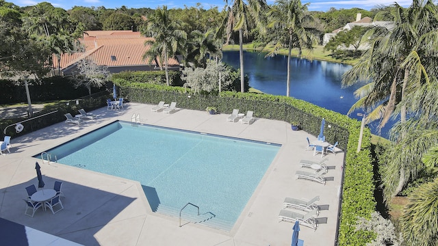 view of pool featuring a water view and a patio