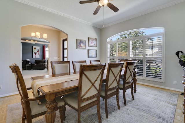 dining space with light parquet flooring, ceiling fan with notable chandelier, and ornamental molding