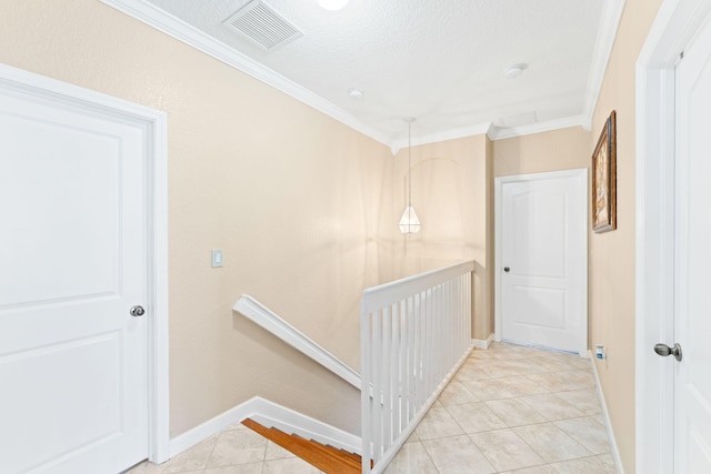 hall with crown molding, light tile patterned floors, and a textured ceiling