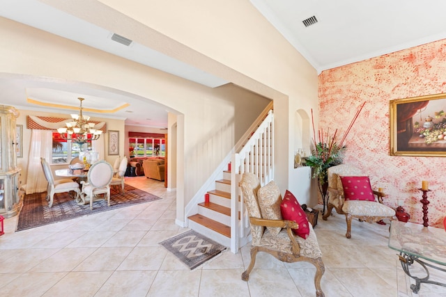 stairway featuring tile patterned floors, a raised ceiling, ornamental molding, and an inviting chandelier