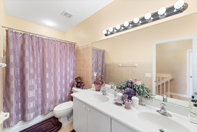 full bathroom featuring shower / bath combo, tile patterned floors, vanity, tile walls, and toilet